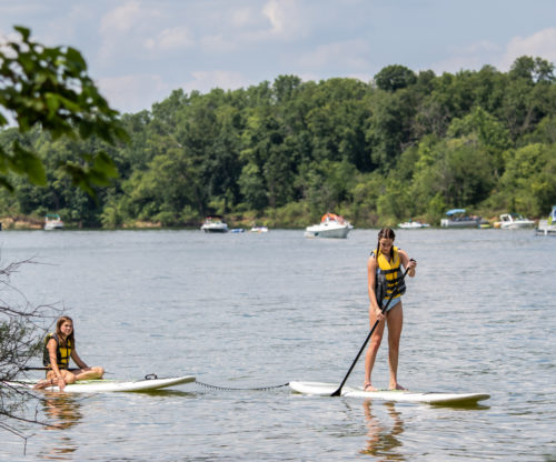 Two kids paddle boarding